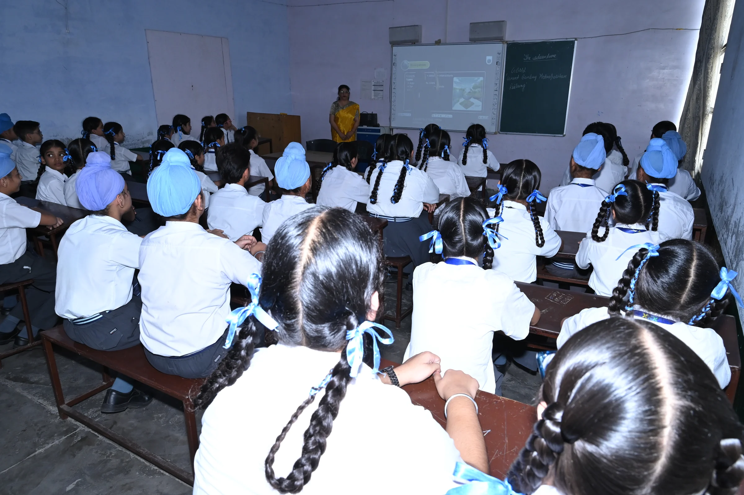 Students attending a lesson with a projected presentation in a smart classroom.